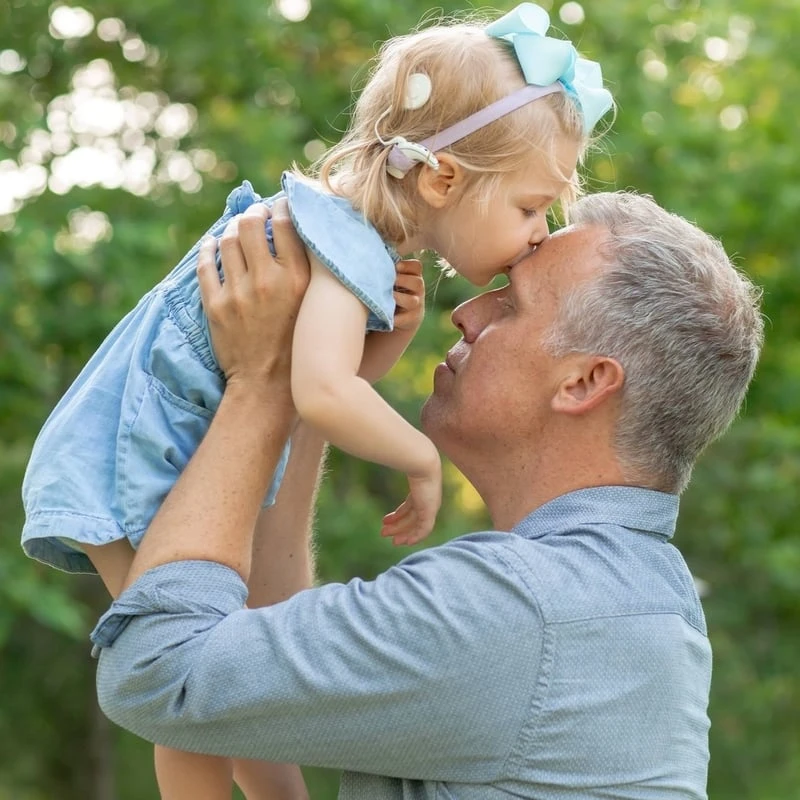 A dad holding his child in the air.