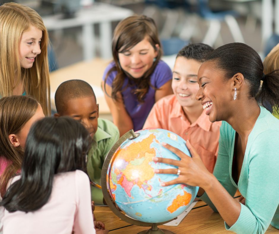 kids and a teacher looking at a globe