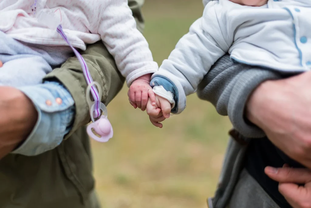 babies holding hands