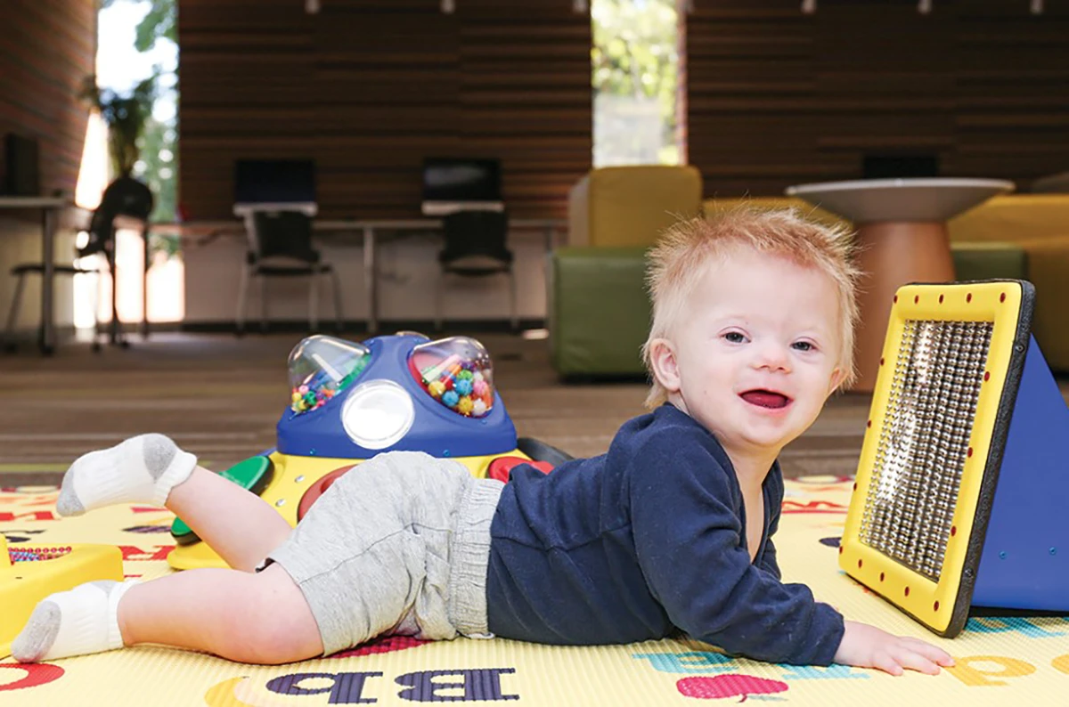 baby playing with library accessibility support collection